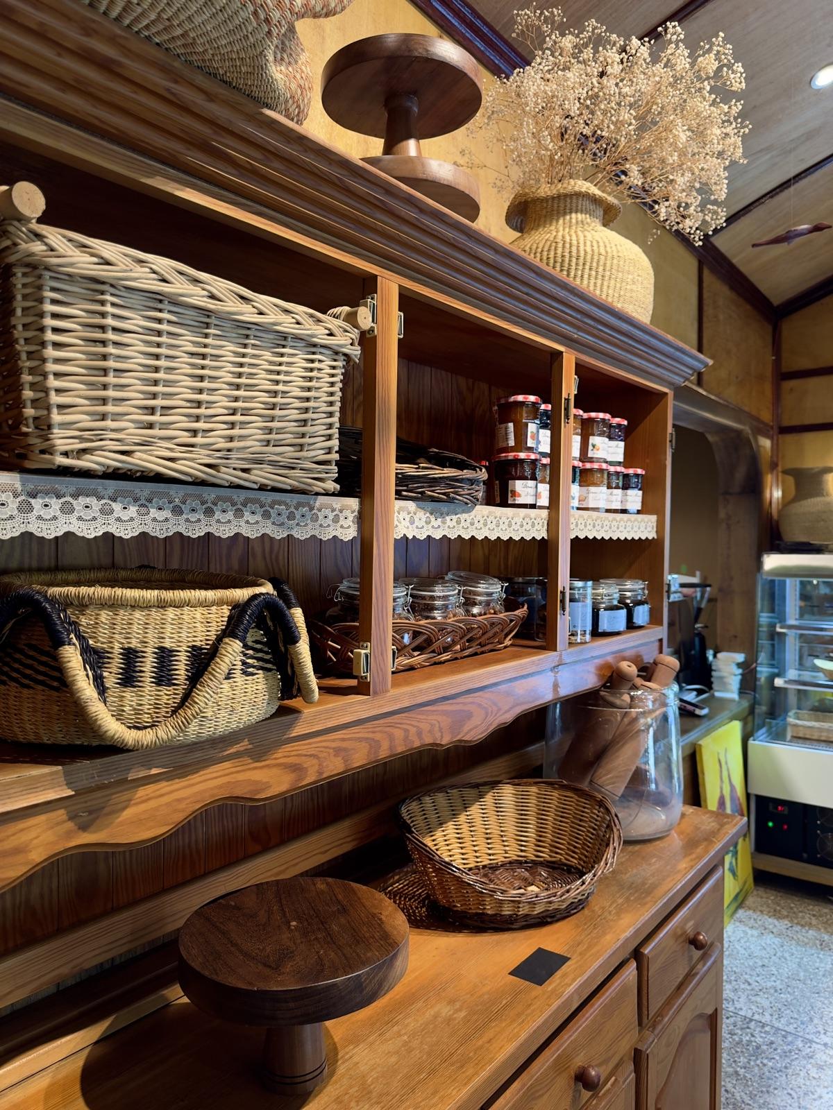 Wooden shelves of jams, jars and woven baskets in the shop